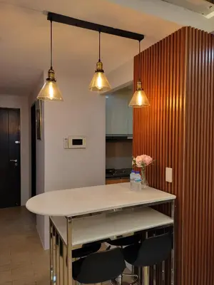 a kitchen with a table with chairs and three lights at The Nest C5-7F EightyOne Newport Boulevard Condominium, Pasay City in Manila