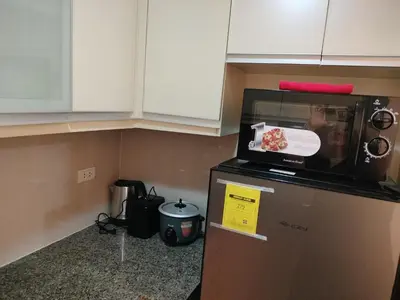 a microwave on top of a refrigerator in a kitchen at The Nest C5-7F EightyOne Newport Boulevard Condominium, Pasay City in Manila