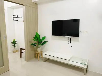 a living room with a flat screen tv hanging on a wall at Condo at Shore 1 with Netflix in Manila