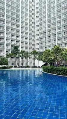 a large apartment building with a large blue swimming pool at Condo at Shore 1 with Netflix in Manila
