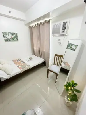a room with a bed and a chair in it at Condo at Shore 1 with Netflix in Manila
