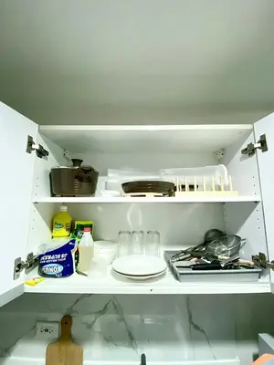 an open kitchen cabinet with a plate and utensils at Ikigai's Alpha Makati City View Condo with Balcony Perfect for Relaxation in Manila