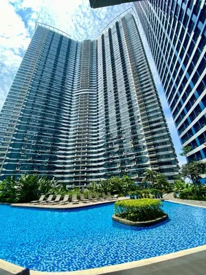 a large building with a large pool in front of it at Ikigai's Alpha Makati City View Condo with Balcony Perfect for Relaxation in Manila