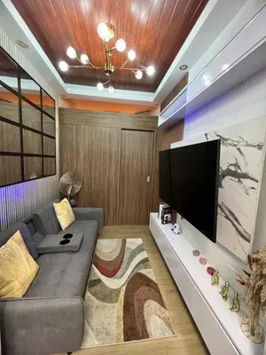a living room with a couch and a flat screen tv at Hadisha Suite Spring Residence in Manila