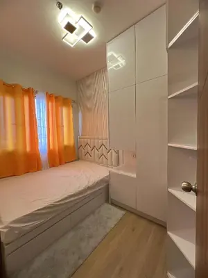a small bedroom with a bed and a window at Hadisha Suite Spring Residence in Manila