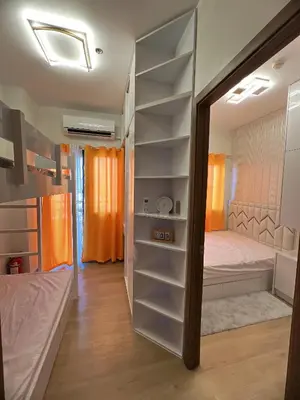 a room with a bed and a closet with shelves at Hadisha Suite Spring Residence in Manila