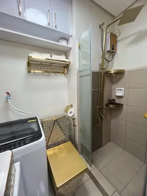 a small bathroom with a shower and a bench at Hadisha Suite Spring Residence in Manila