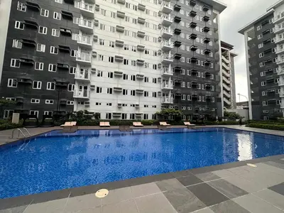a swimming pool in front of a large building at The Finest Charm Residences by Ashti in Manila