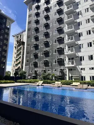 a large apartment building with a swimming pool in front of it at The Finest Charm Residences by Ashti in Manila