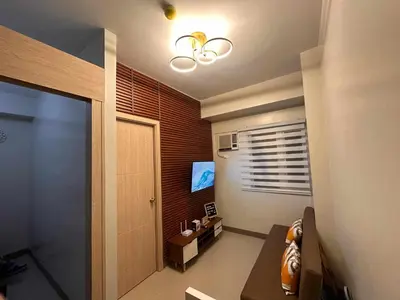 a room with a hallway with a door and a television at The Finest Charm Residences by Ashti in Manila