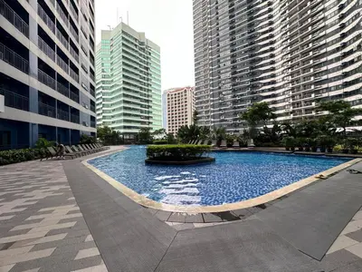 a large swimming pool in a city with tall buildings at Air Residence- Makati in Manila