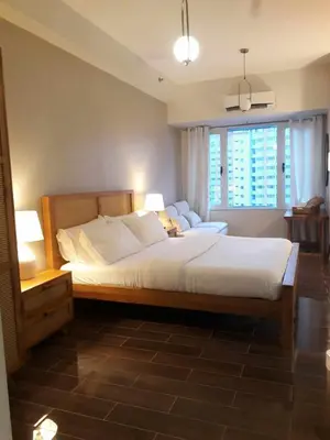 a bedroom with a large bed and a window at Air Residence- Makati in Manila