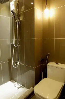 a bathroom with a shower with a toilet and a sink at Air Residence- Makati in Manila