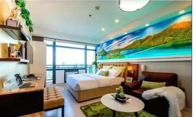 a bedroom with a bed and a large painting on the wall at Gramercy Century City Makati in Manila