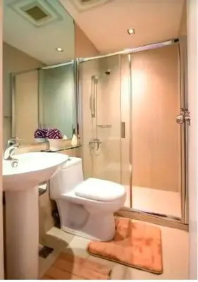 a bathroom with a toilet and a shower and a sink at Gramercy Century City Makati in Manila