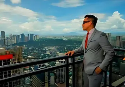 a man in a suit and tie standing on a balcony at Gramercy Century City Makati in Manila