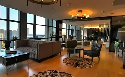 a living room with a couch and a table and chairs at Gramercy Century City Makati in Manila