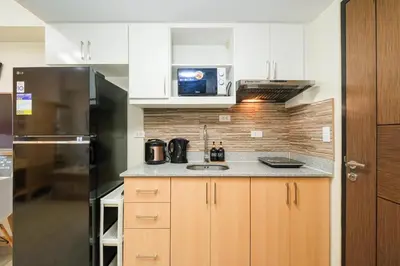 a kitchen with a sink and a refrigerator at Skyline Stay in Manhattan in Manila