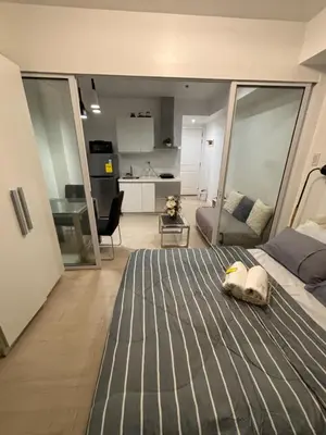 a bedroom with a bed and a living room at Azure Urban Resort Residences in Manila
