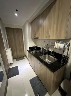 a kitchen with a sink and wooden cabinets at Vince Cozy Staycation in Manila