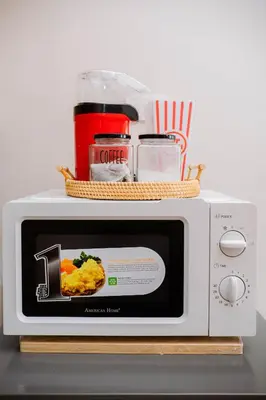 a microwave with a plate of food on top of it at Oranje Suite Near Naia Terminal in Manila