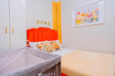 a bedroom with a bed with an orange headboard at Oranje Suite Near Naia Terminal in Manila