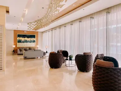 a lobby with couches and chairs in a building at Oranje Suite Near Naia Terminal in Manila