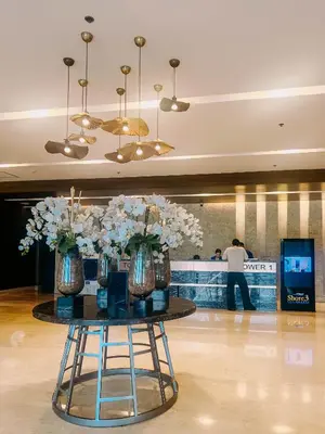 a table with vases of flowers on it in a lobby at Oranje Suite Near Naia Terminal in Manila