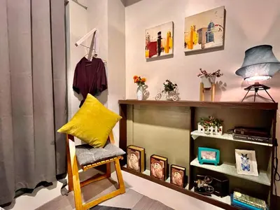 a room with a chair and a shelf with pictures at Central Makati CBD in Manila