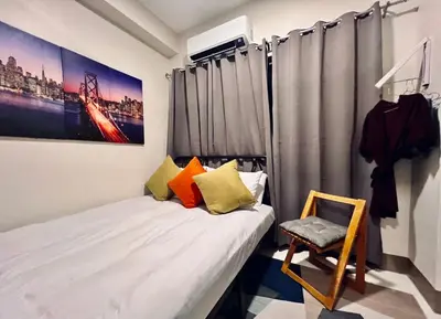 a small bedroom with a bed and a chair at Central Makati CBD in Manila