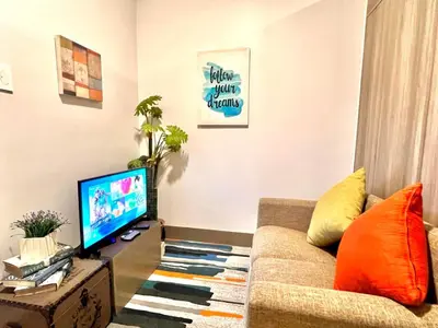 a living room with a couch and a television at Central Makati CBD in Manila