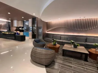 a lobby with a couch and a chair and a table at Cozy Home in Mall of Asia - Aseana Pasay in Manila