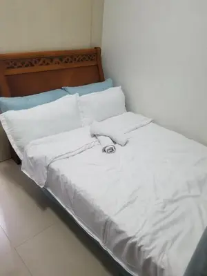 a bed with white sheets and pillows on it at SEA RESIDENCES AFFORDABLE STAYCATIONs in Manila