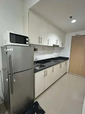 a kitchen with a stainless steel refrigerator and a sink at SEA RESIDENCES AFFORDABLE STAYCATIONs in Manila
