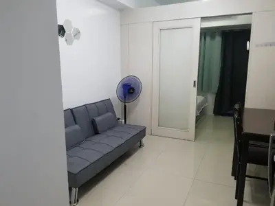 a living room with a couch and a table at SEA RESIDENCES AFFORDABLE STAYCATIONs in Manila