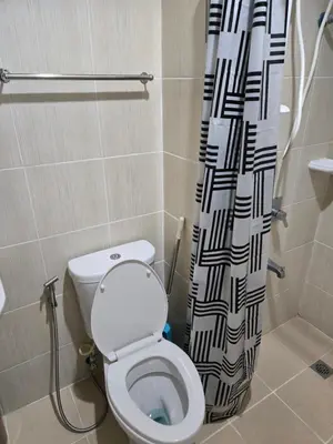 a bathroom with a toilet and a shower curtain at Staycation near US Embassy in Manila