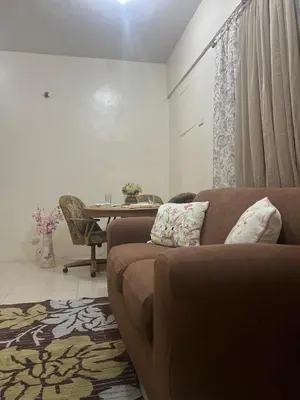 a living room with a couch and a table at Laureano Di Trevi Tower in Manila