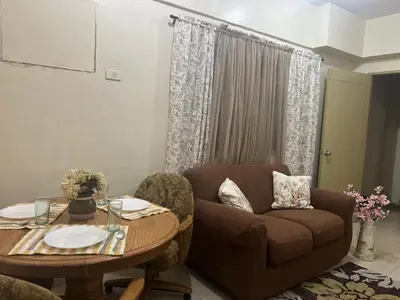 a living room with a couch and a table at Laureano Di Trevi Tower in Manila