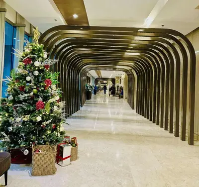 a long hallway with christmas trees in a mall at Urban Luxe Stay at Shore 3 in Manila