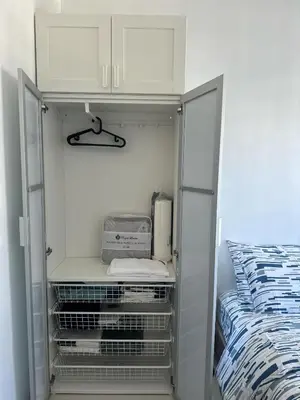 a closet with a bed and a white cabinet at Urban Luxe Stay at Shore 3 in Manila