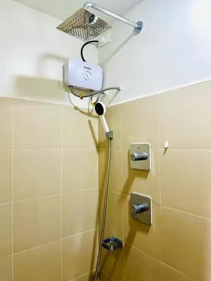 a shower in a bathroom with a blow dryer at Cozy Hearth Loft at Shore 3 in Manila