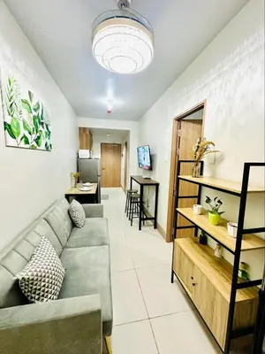 a living room with a couch and a table at Cozy Hearth Loft at Shore 3 in Manila