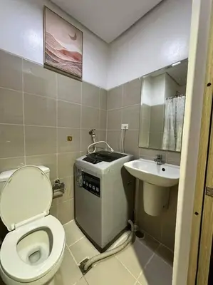 a small bathroom with a toilet and a sink at Cozy orange room at shore in Manila