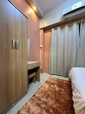 a bedroom with a bed and a bathroom with a sink at Cozy orange room at shore in Manila