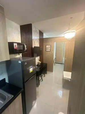 a kitchen with a refrigerator and a table with chairs at Nalin house SHORE 2 Residences in Manila