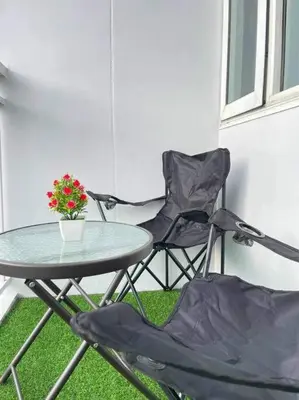 a table and two chairs and a table with a plant at Shore Residences Staycation by K in Manila