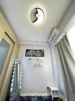 a room with a ceiling with a clock and a window at Shore Residences Staycation by K in Manila