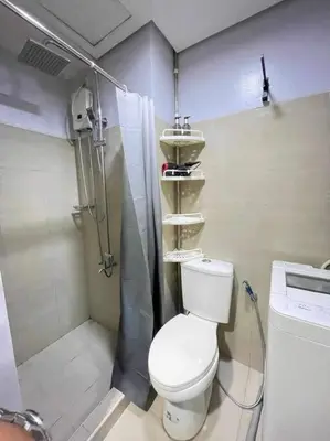 a small bathroom with a toilet and a shower at Shore Residences Staycation by K in Manila