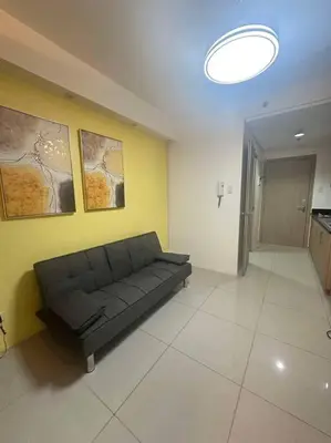 a black couch in a room with a yellow wall at Cozy shore 1 residences in Manila