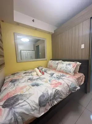 a bedroom with a bed with a mirror on the wall at Cozy shore 1 residences in Manila